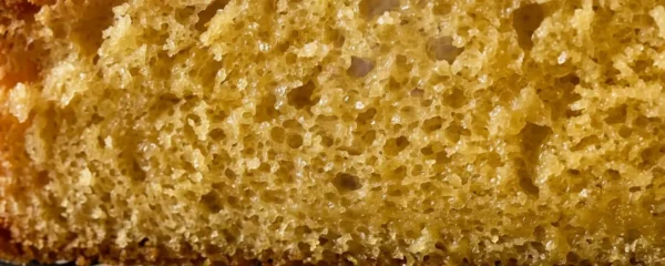 Cake doré sur une grille avec texture moelleuse visible en coupe