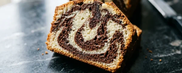 Gâteau marbré coupé révélant des volutes parfaites de chocolat et vanille