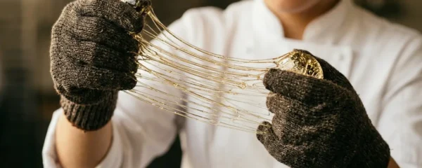 Pâtissier travaillant l'isomalt avec précision et concentration dans un atelier professionnel