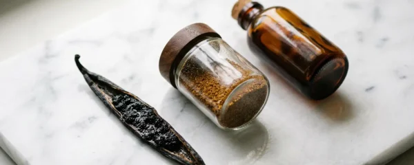 Différents formats de vanille Bourbon disposés élégamment sur une surface en marbre blanc